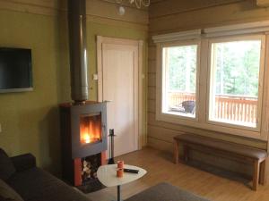 a living room with a fireplace and a couch at Pyhäjärven Lomakylä in Ruolahti