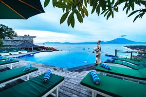 a person standing next to a swimming pool with a water fountain at Jenggala Hill in Nusa Lembongan