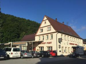 a large white building with cars parked in front of it at Gasthof zur Post in Zwiefalten