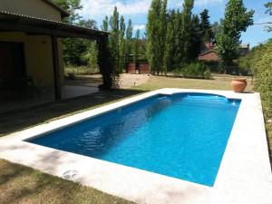 a swimming pool in the yard of a house at Cabaña Josefina in Los Reartes +9 photos