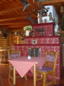 a dining room with a table and chairs and a fireplace at Pension Grizzly in Ludvíkov
