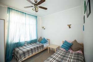 a bedroom with two beds and a ceiling fan at Guest House Dom 17 in Rostov on Don