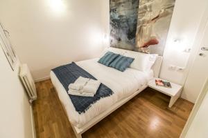 a small bedroom with a bed with white sheets and blue pillows at Arsenale Design Apartment R&R in Venice