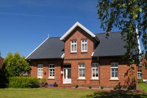 a red brick house with a black roof at Landhaus von Felde in Esens