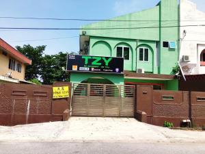 a green building with a garage with a clock on it at Ipoh TZY's Homestay in Ipoh