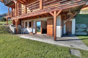 a wooden house with a dog laying on a deck at Altiplano 003 in Verbier +1 photo