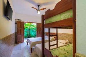 a bedroom with two bunk beds and a ceiling fan at Pousada Camila in Paraty