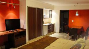a room with a bed and a desk with a television at Casacerro in Salta