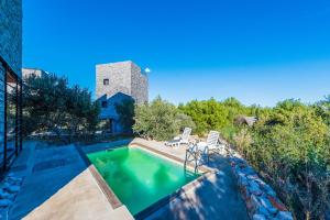a swimming pool with two chairs and a building at Villa Kula in Dragove