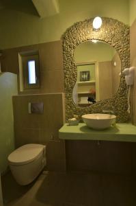 a bathroom with a sink and a toilet and a mirror at Portes Houses in Koufonisia