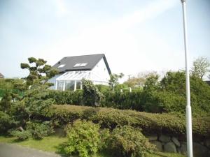 a house with a solar roof on top of a hedge at Ferienwohnung Liane in Sassnitz