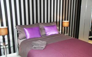 a bedroom with a purple bed with two lamps at Köln-Kerpen Boutique-Ferienwohnungen Angela & Maurizio in Kerpen