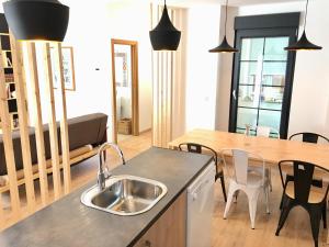 サラゴサにあるApartamento Vive Zaragozaのキッチン(シンク、テーブル、椅子付)