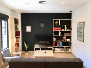 sala de estar con sofá y estante para libros en Apartamento Vive Zaragoza, en Zaragoza