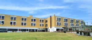 a large building with a grass field in front of it at Aguas del Monte Hotel SPA in San Miguel del Monte