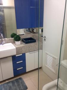 a bathroom with blue and white cabinets and a sink at Maravilhoso Apartamento na Beira Mar in Fortaleza