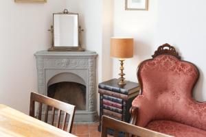 ein Wohnzimmer mit einem Stuhl und einem Kamin in der Unterkunft Villa Torricelli Scarperia - Il Giardinetto Residence in Scarperia