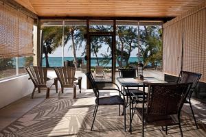 un patio con mesa, sillas y el océano en Hollywood Beach Suites Turks and Caicos, en NCA