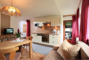 a kitchen and living room with a couch and a table at Haus Katharina in Westendorf
