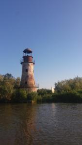 a lighthouse sitting on the side of a river at Casa Diana in Sulina