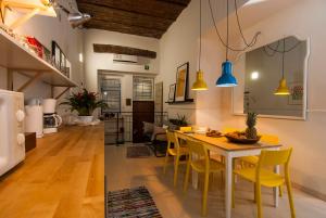 Il dispose d'une cuisine et d'un salon avec une table et des chaises jaunes. dans l'établissement The yellow house, à Rome