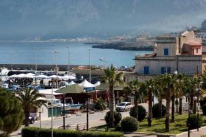 a town with palm trees and a body of water at Casa Piano Ponente in Isola delle Femmine