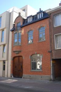 ein rotes Backsteingebäude in einer Stadtstraße in der Unterkunft Hollandia City Distillery in Hasselt