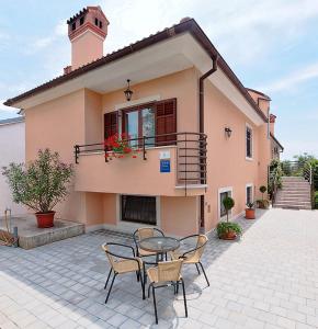 eine Terrasse mit einem Tisch und Stühlen vor einem Haus in der Unterkunft Apartments Villa Brigita in Rovinj