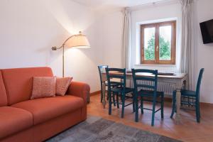 a living room with a couch and a table and chairs at COLVAGO CIMA DODICI – DOLOMITES NATIONAL PARK in Santa Giustina