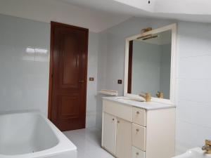 a white bathroom with a sink and a mirror at Villetta Miramonti in Forte dei Marmi