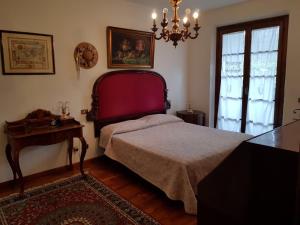 フォルテ・デイ・マルミにあるVilletta Miramontiのベッドルーム1室(ベッド1台、テーブル、シャンデリア付)