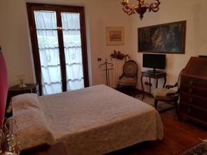 a bedroom with a bed and a dresser and a window at Villetta Miramonti in Forte dei Marmi