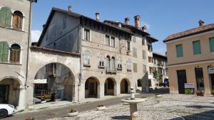 an old building with a fountain in the middle of a street at COLVAGO CIMA DODICI – DOLOMITES NATIONAL PARK in Santa Giustina