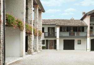 a building with columns and flowers in a courtyard at Colvago La Corte Spectacular Ancient Country House in Santa Giustina