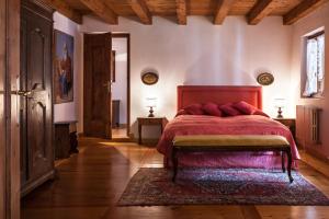 a bedroom with a bed with a red bedspread at Colvago La Corte Spectacular Ancient Country House in Santa Giustina