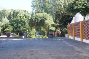 a brick road with vases and a fence at Quartos do Lagar in Golegã +3 photos