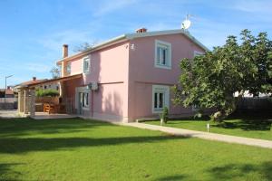 różowy dom z trawnikiem w obiekcie Vacation house "Viola" w Fažanie