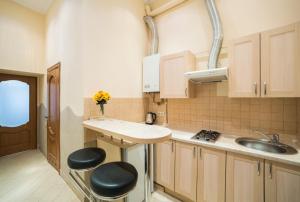 a kitchen with a sink and two stools in it at Apartment on Svobody in Lviv
