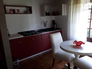a kitchen with red cabinets and a table with a red bow at Casarão Villa maggi in Canela