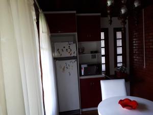 a kitchen with a white refrigerator and a table with a red bow at Casarão Villa maggi in Canela