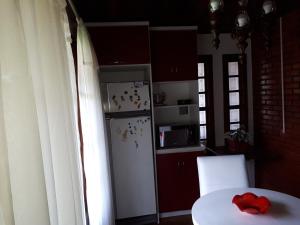 cocina con nevera blanca y mesa con arco rojo en Casarão Villa maggi, en Canela