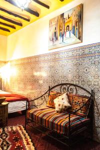 a bedroom with a bed with a mosaic wall at Riad Tiziri in Marrakesh