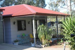 a small white house with a red roof at Ducati's B and B in Raymond Terrace