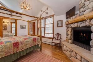 1 dormitorio con chimenea, 1 cama y TV en Minturn Inn en Minturn