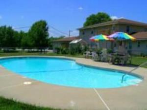 a large blue swimming pool with an umbrella at Best Budget Inn in Carthage