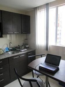 una cocina con mesa y ordenador portátil. en Carolina Family Suite, en Quito