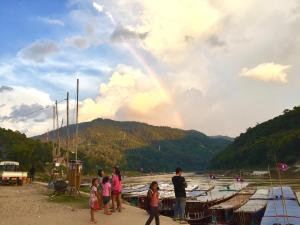 een groep mensen die voor een regenboog staan bij Syvongsack Guesthouse in Pakbeng