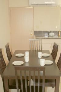 a dining room table with white dishes on it at Casa De Pedro in Mangilao