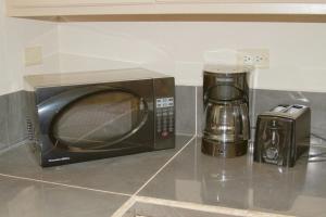 a microwave sitting on a counter next to a coffee maker at Casa De Pedro in Mangilao