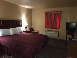 a hotel room with a bed and a flat screen tv at Camino Real Hotel in Eagle Pass